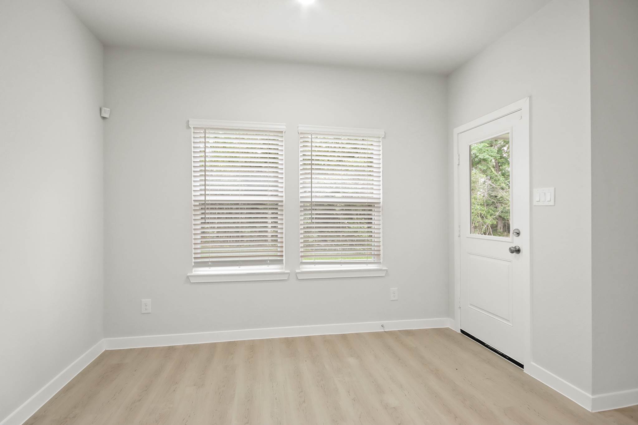A room with a wood floor and white walls.
