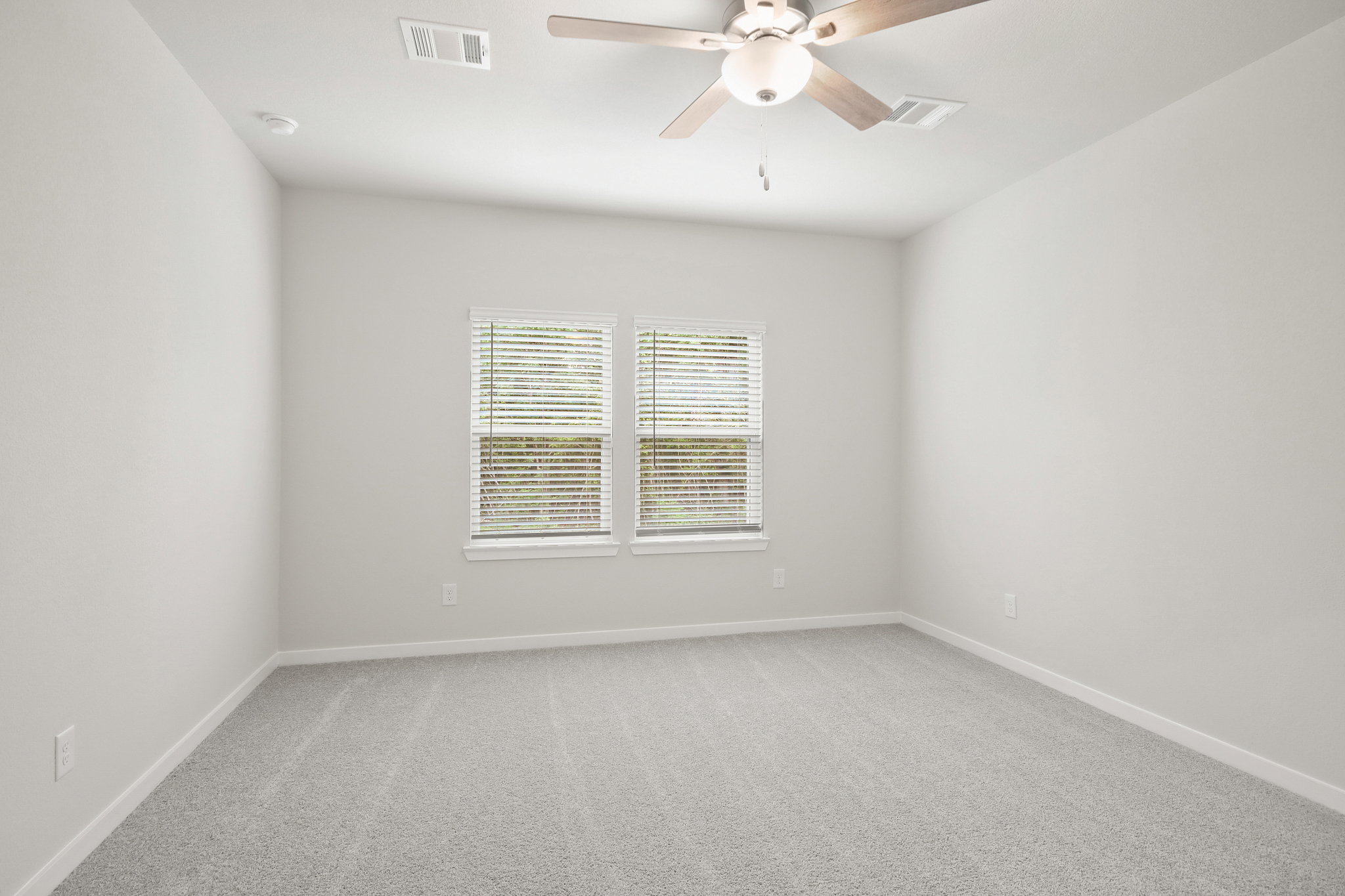 A room with a ceiling fan and a window.