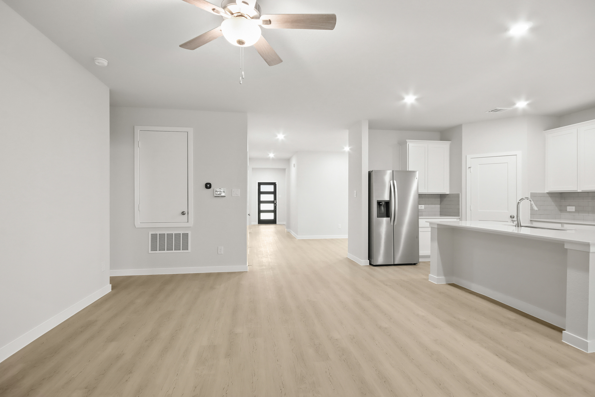 A kitchen with white cabinets.