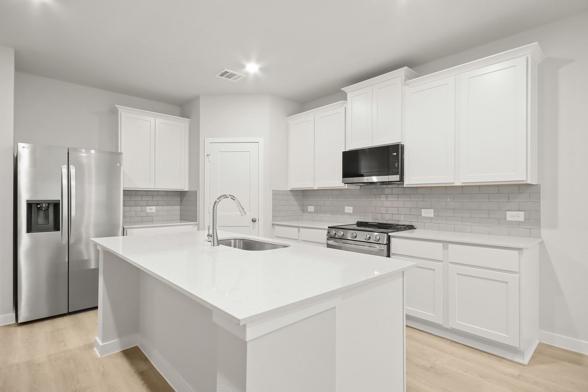 A kitchen with white cabinets.