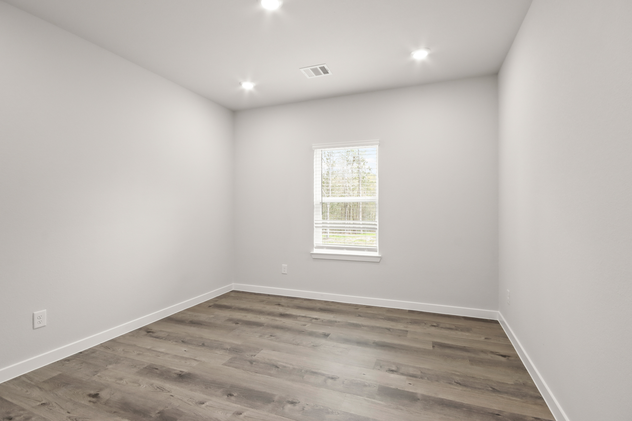 A room with a wood floor and a window.