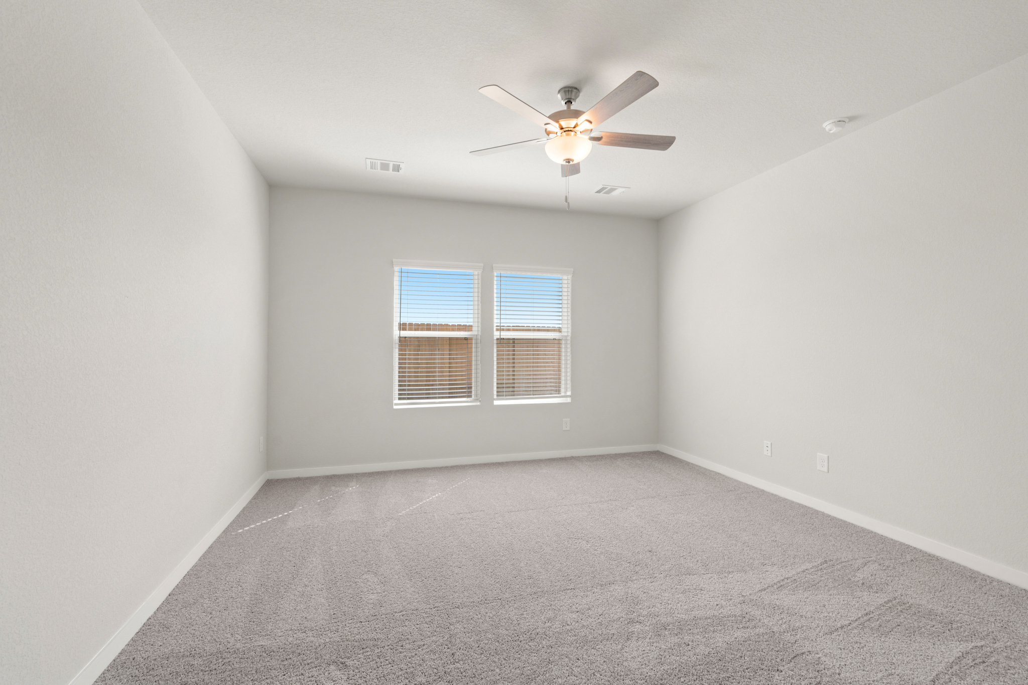 A room with a ceiling fan and a window.
