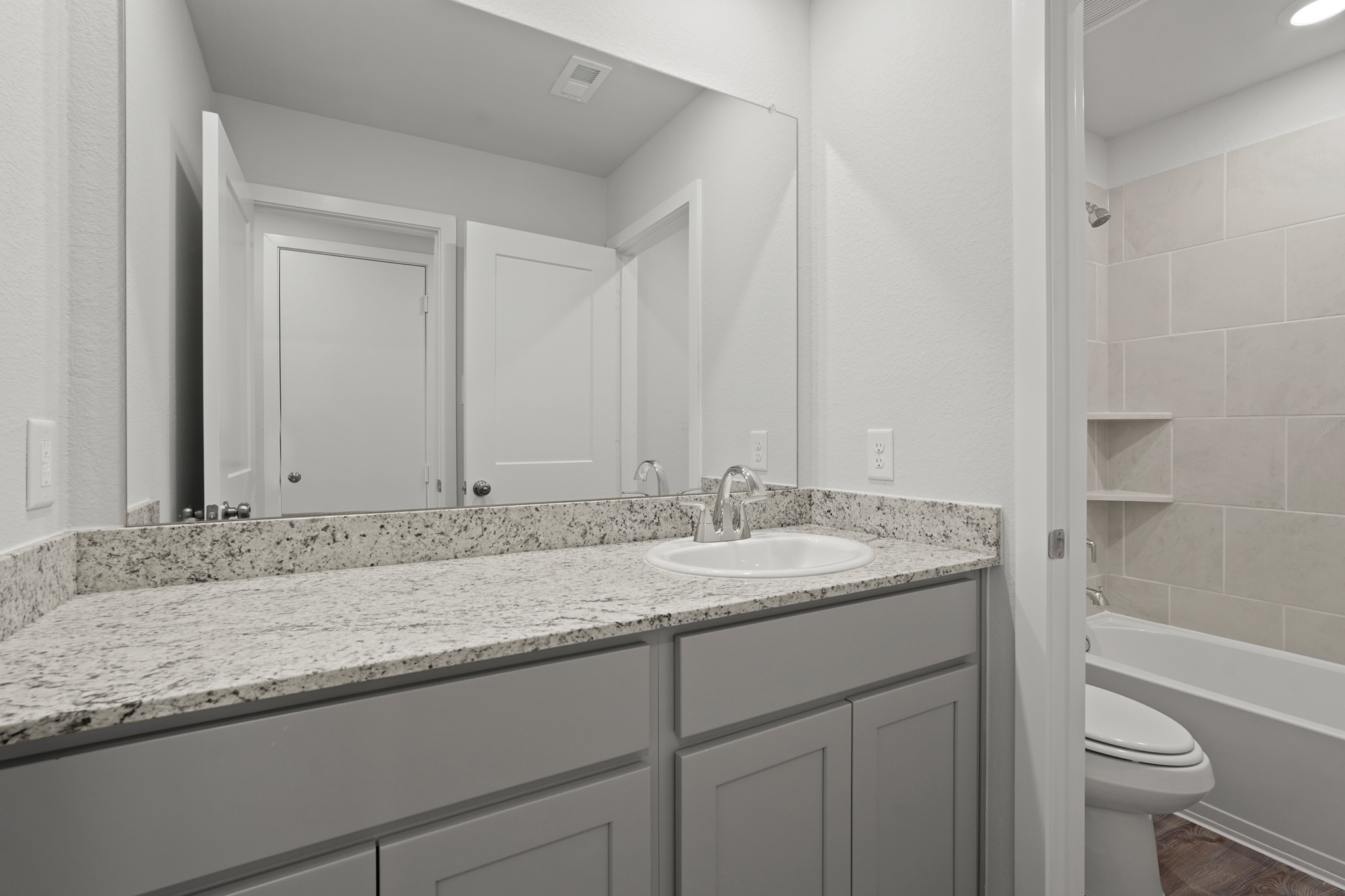 A bathroom with marble countertop.