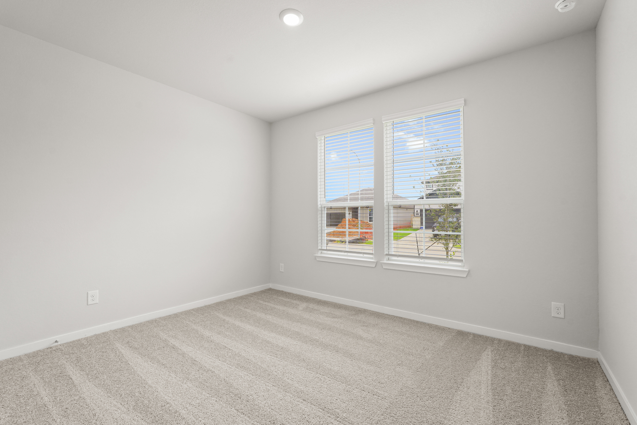 A room with a window and a carpet.