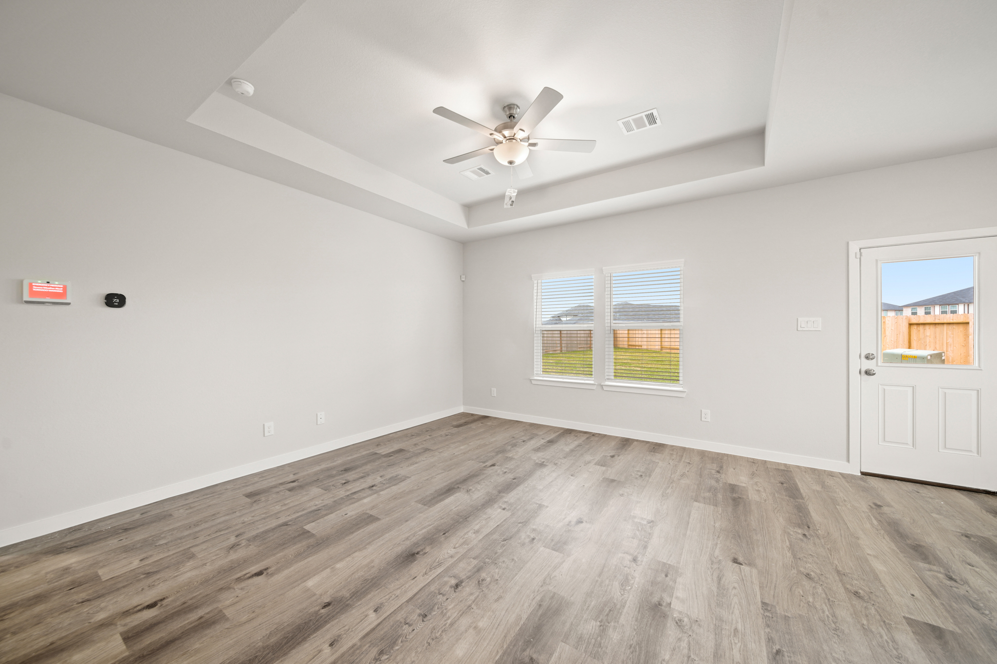 A room with a wood floor and a ceiling fan.