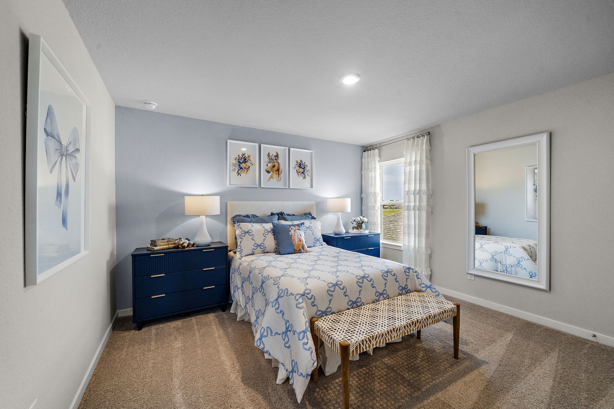 A bedroom with a bed and a bench.