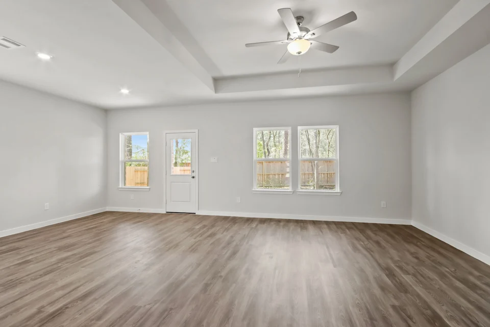 A room with a wood floor and a ceiling fan.