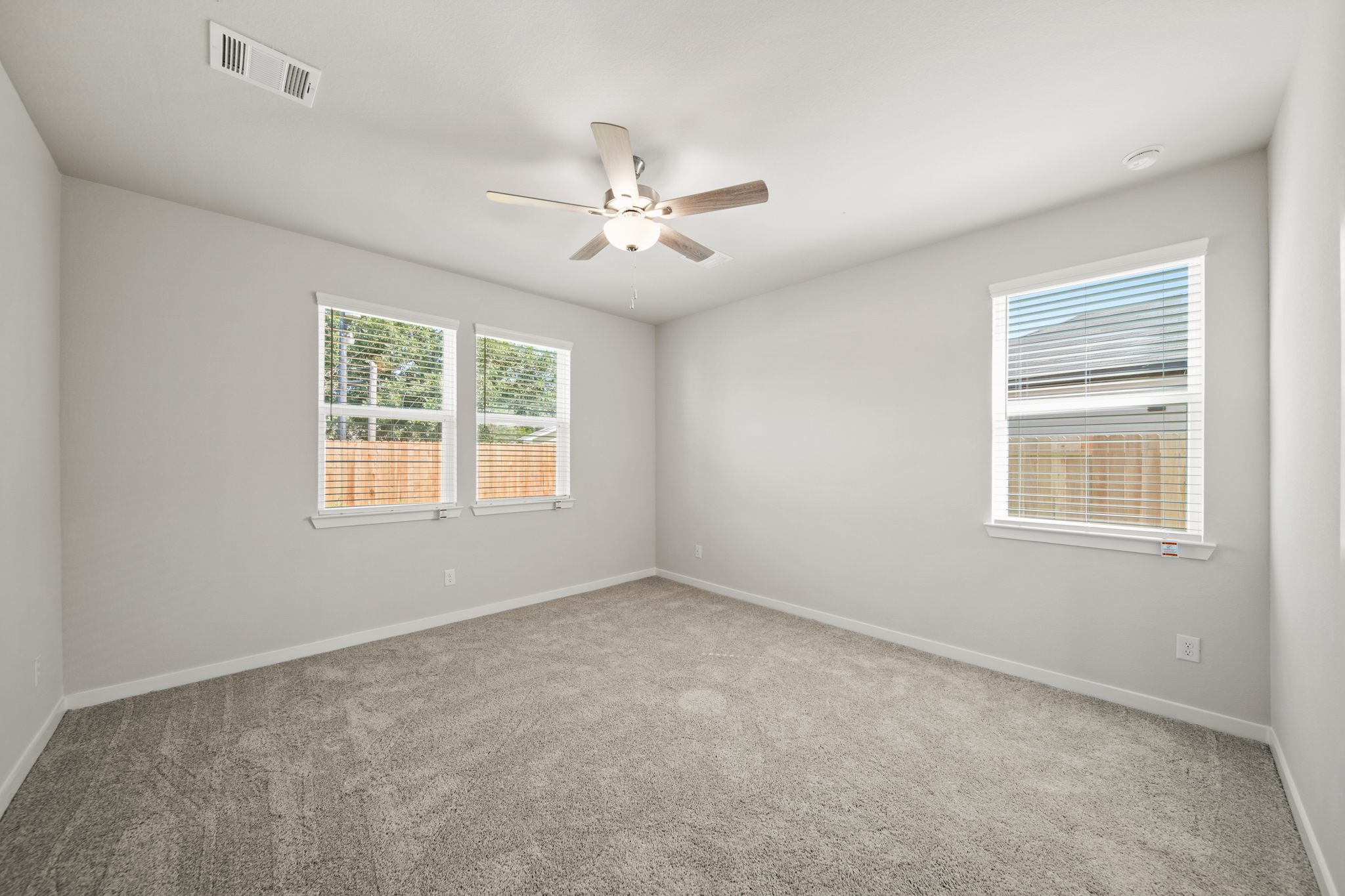 A room with a ceiling fan and a window.