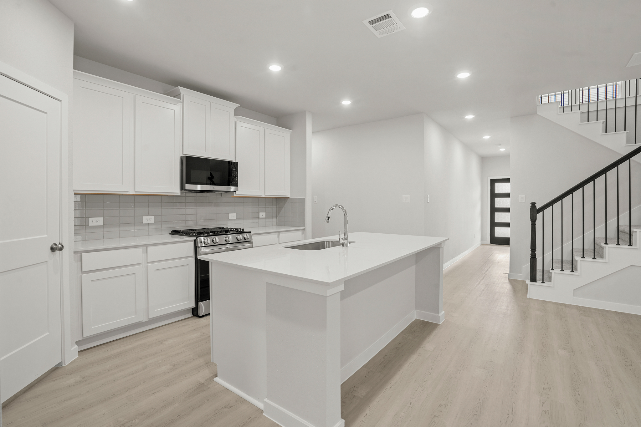 A kitchen with white cabinets.