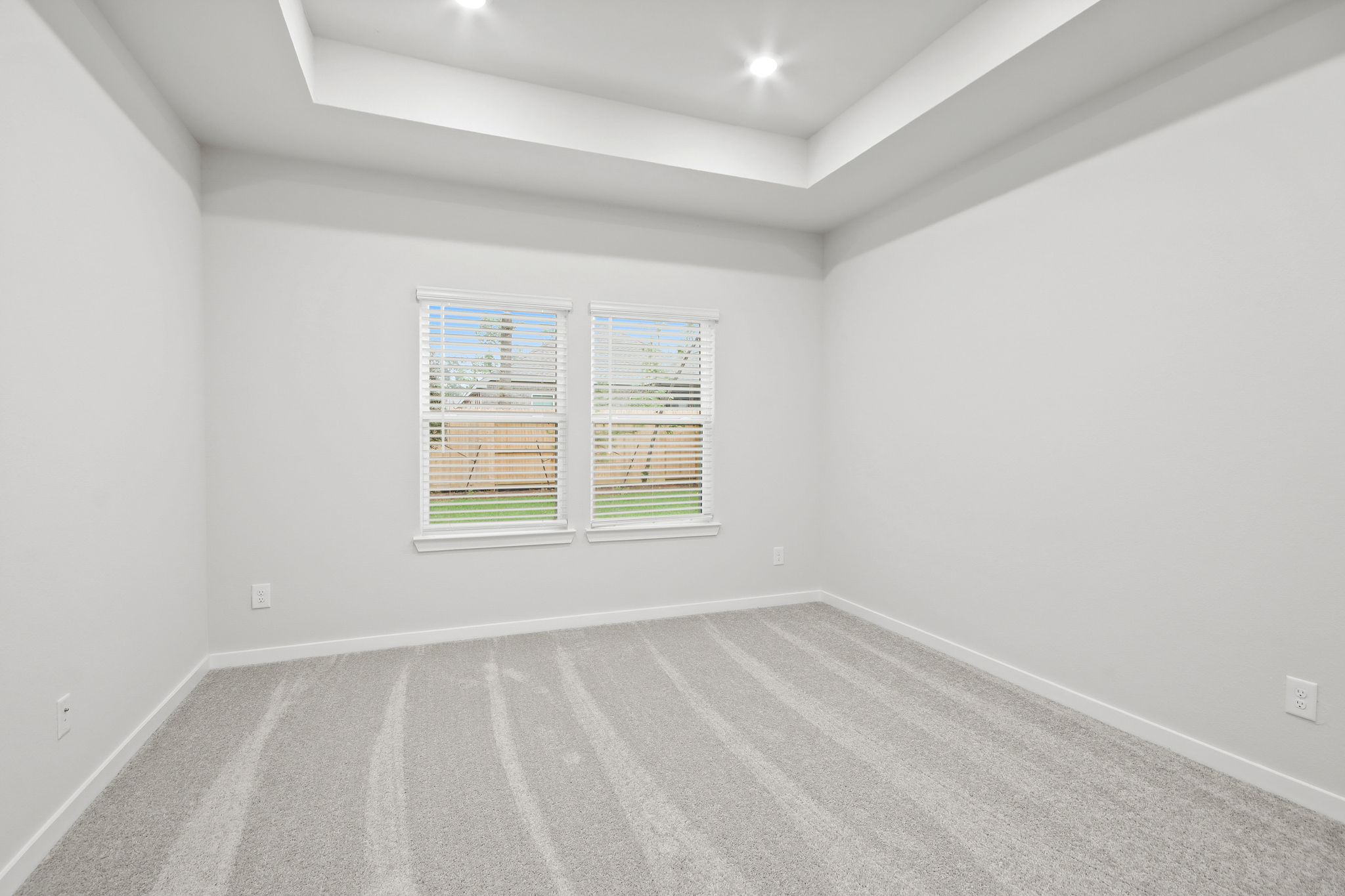 A room with a window and a rug.