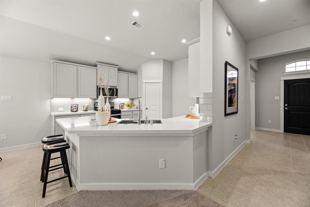 A kitchen with white cabinets.