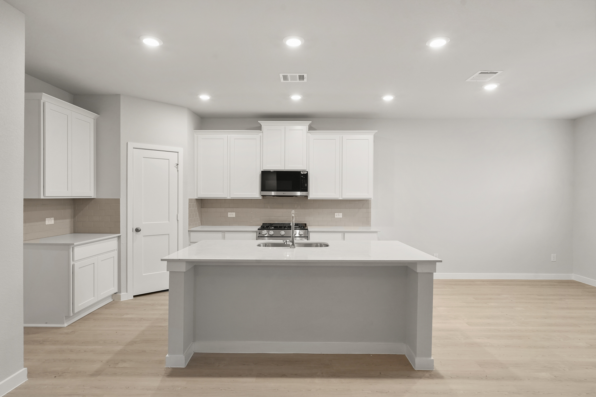 A kitchen with white cabinets.
