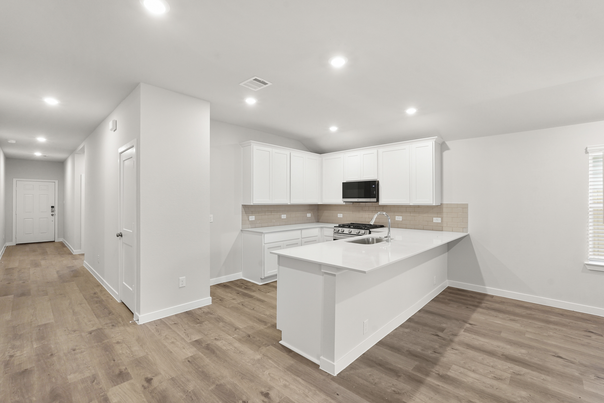 A kitchen with white cabinets.