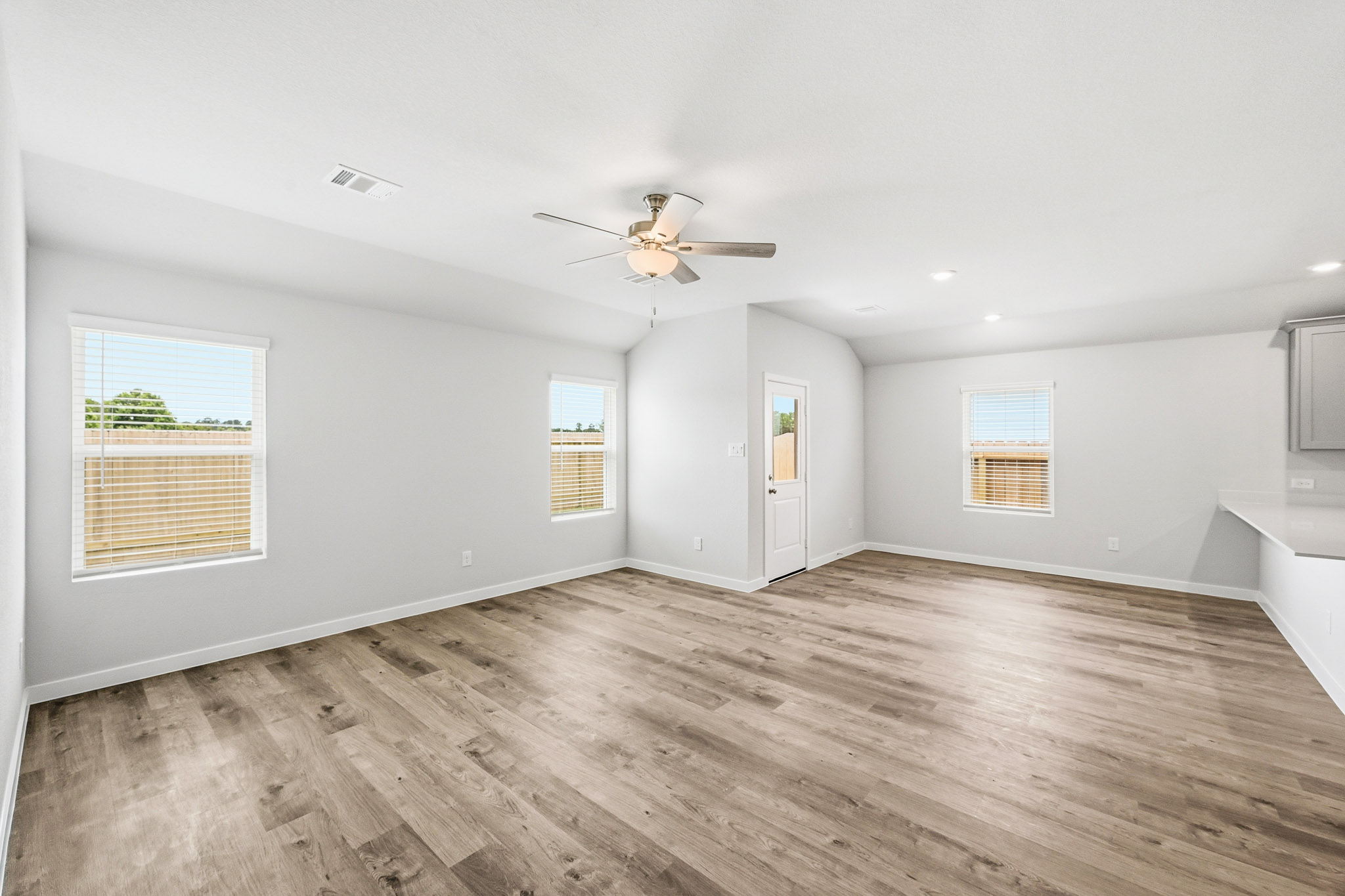 A room with a wood floor and a ceiling fan.