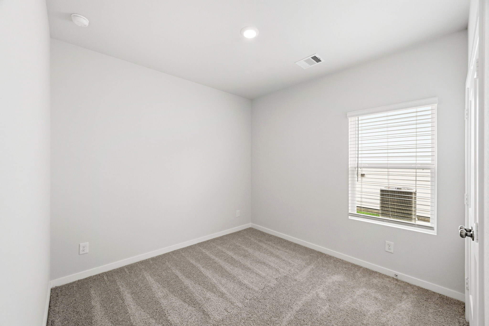 A room with a window and carpet.
