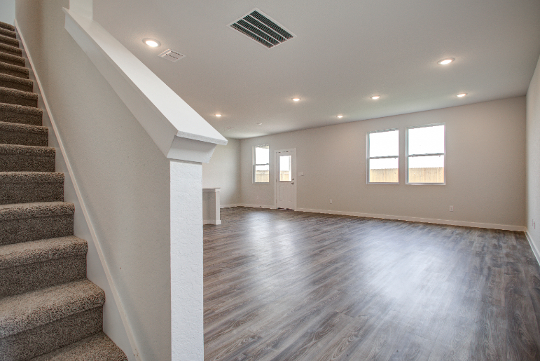 A long hallway with a wood floor.