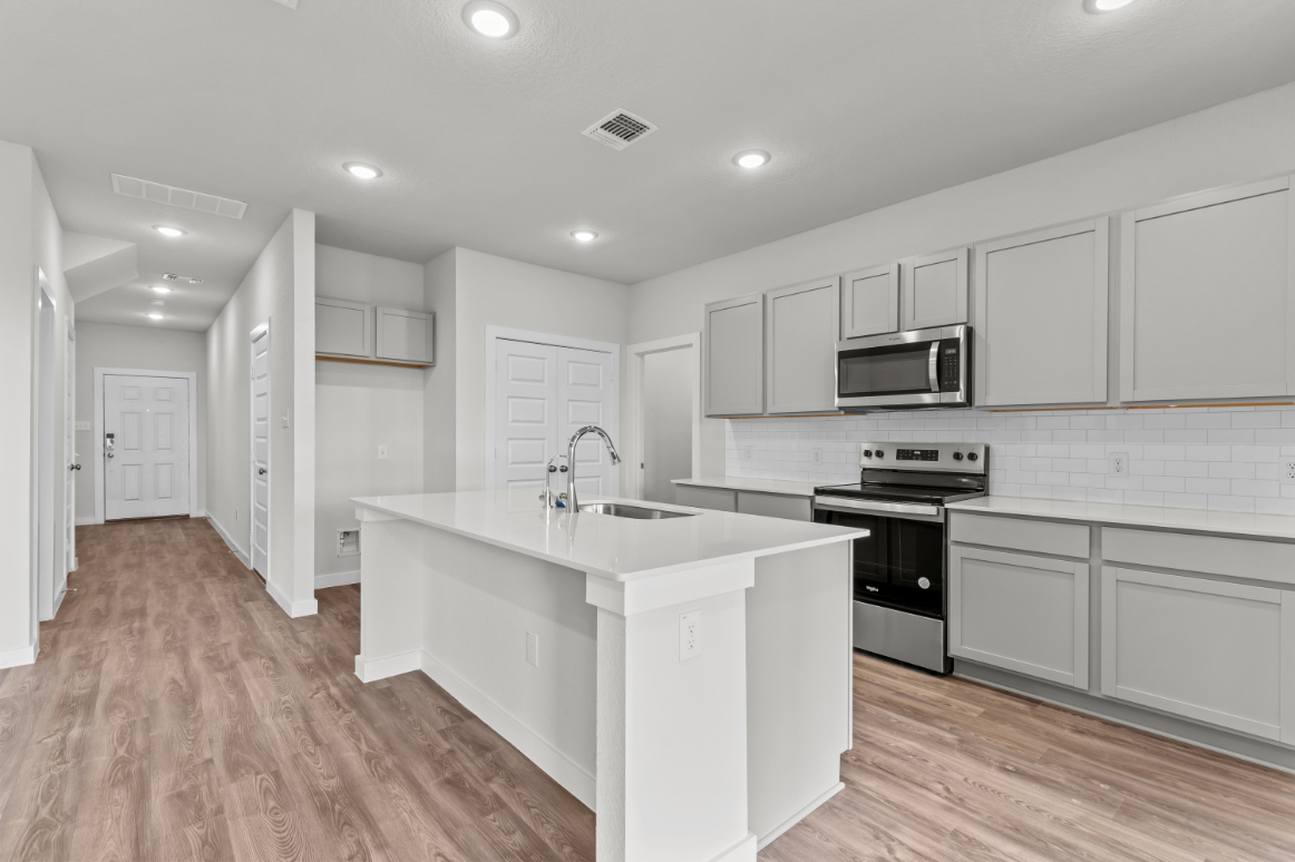 A kitchen with white cabinets.