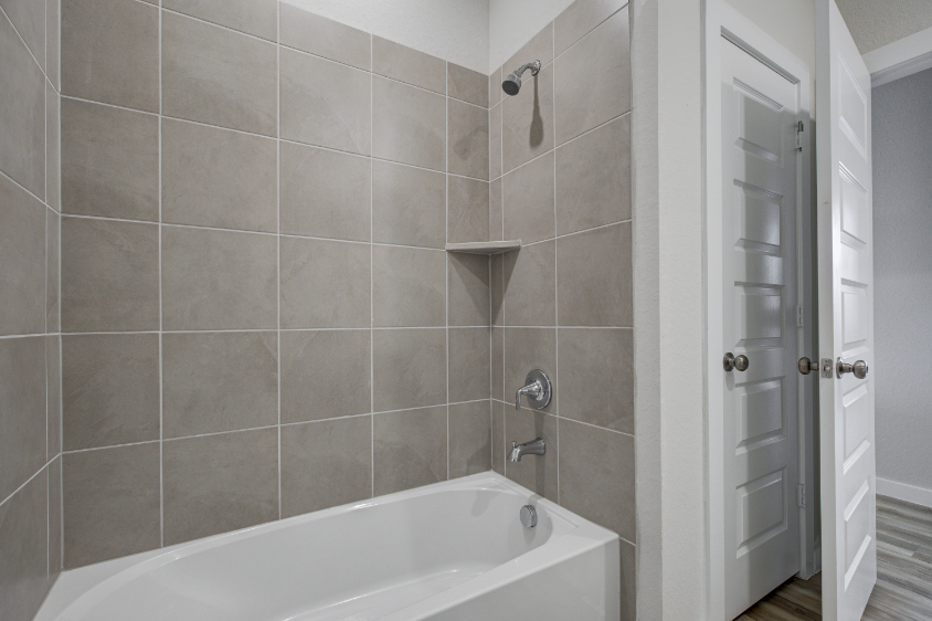A bathroom with a bathtub and shower.