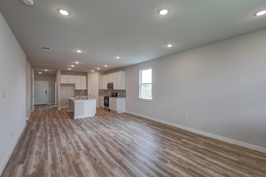 A room with white walls and wood floors.