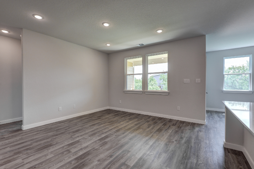 A room with windows and wood floor.