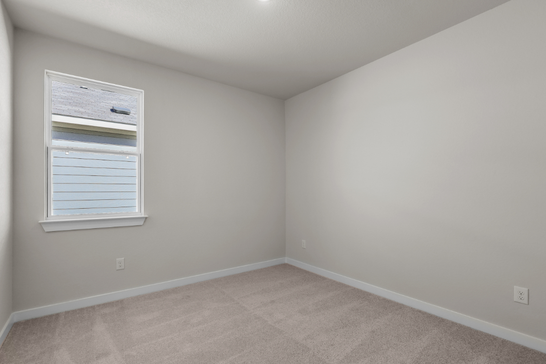 A room with a window and a carpet.