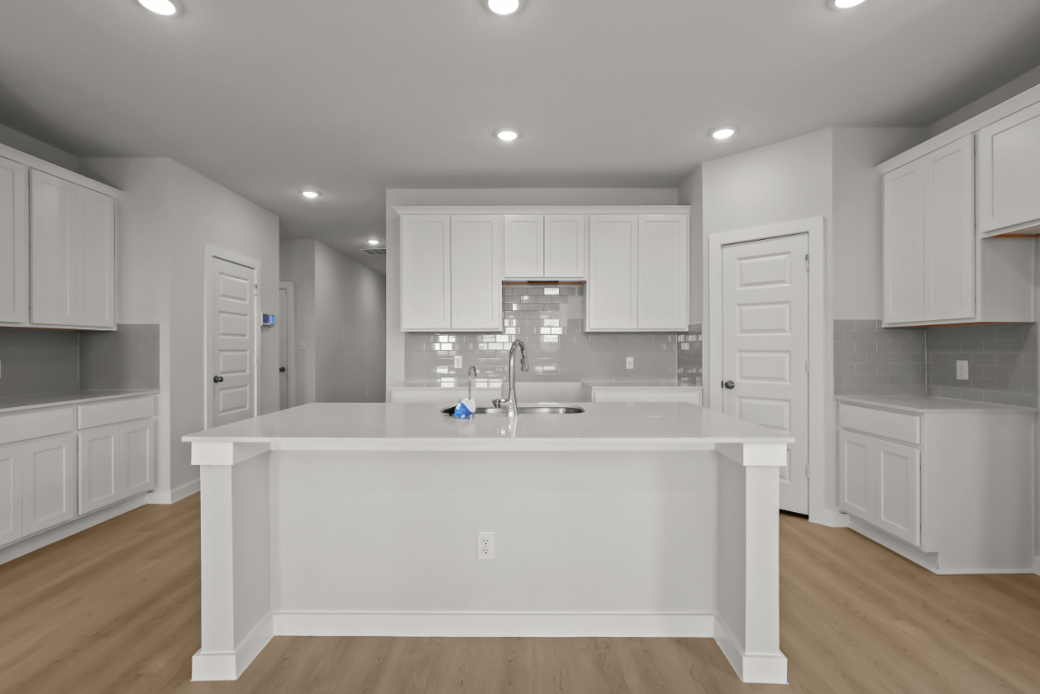 A kitchen with white cabinets.