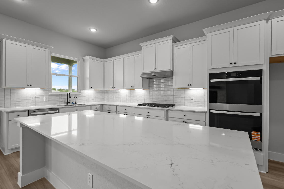A kitchen with white cabinets.