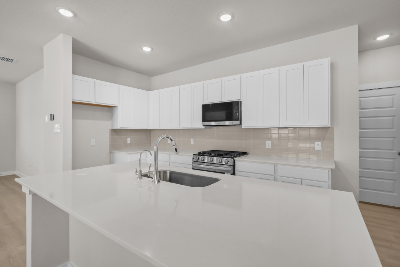 A kitchen with white cabinets.