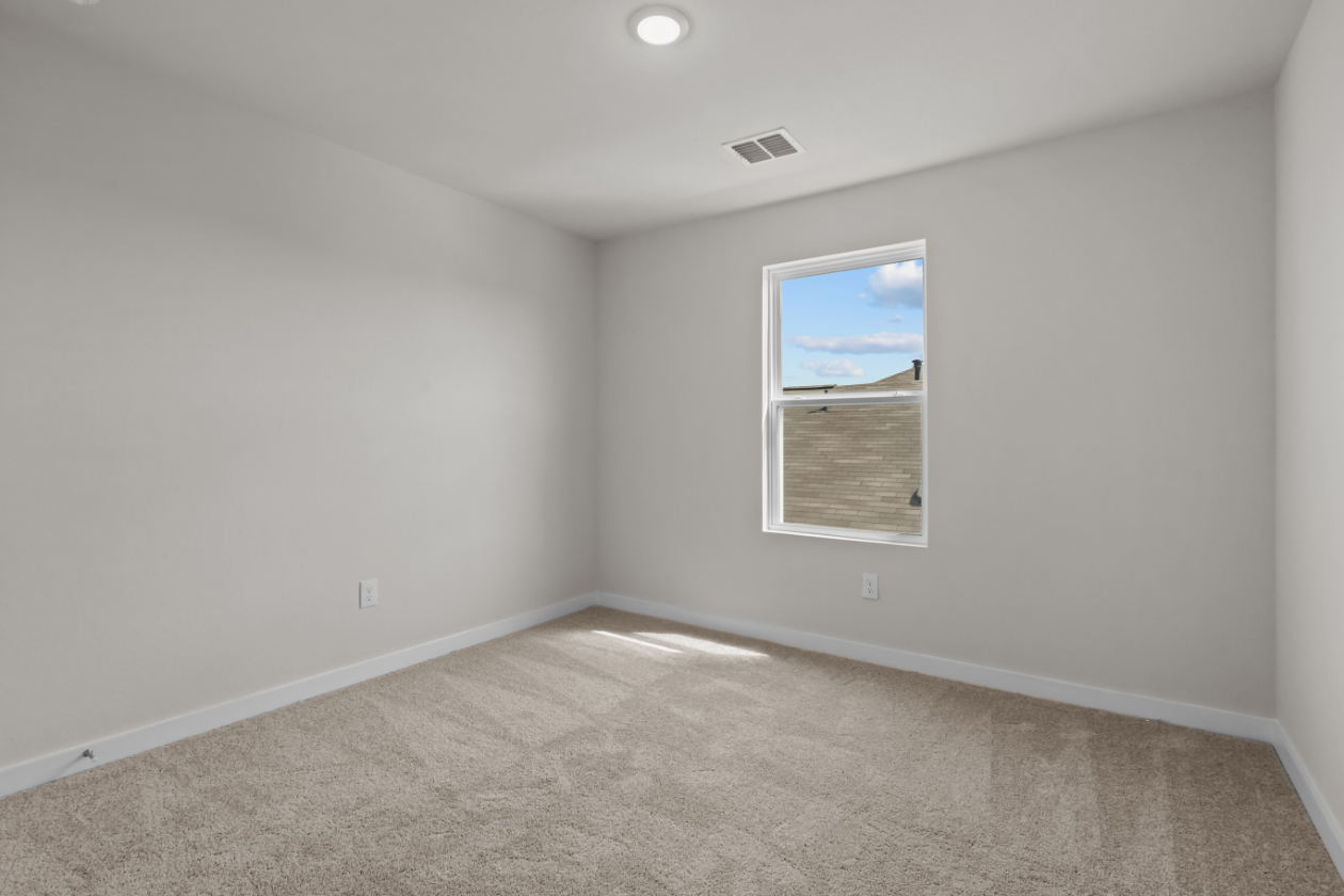 A room with a window and a carpet.