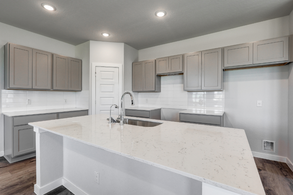 A kitchen with white cabinets.