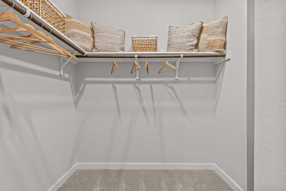 A white shelf with a chair and pillows on it.