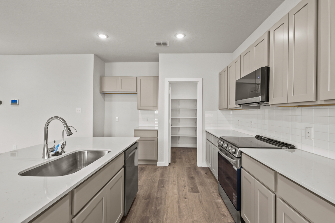 A kitchen with white cabinets.