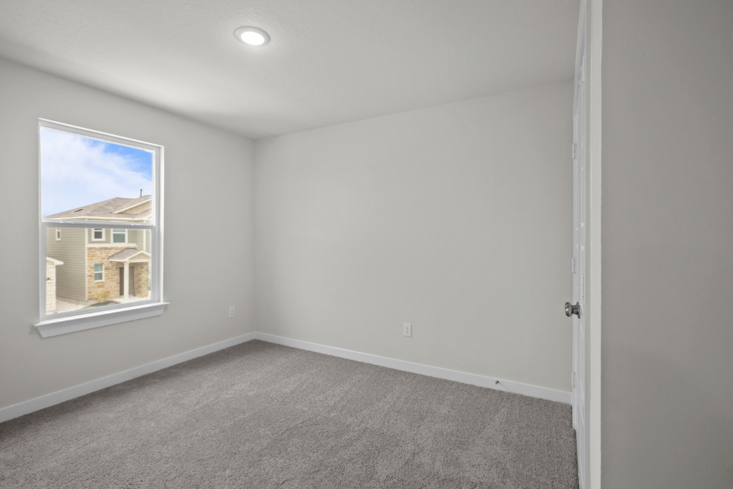 A room with a carpet and a window.