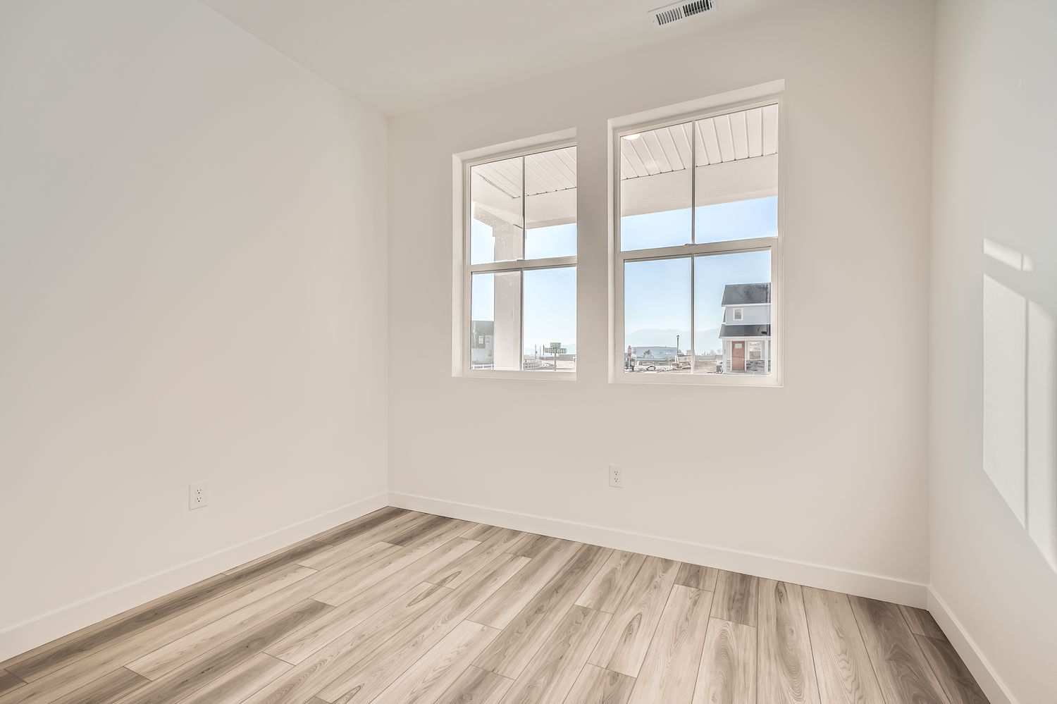 A room with a wood floor and windows.