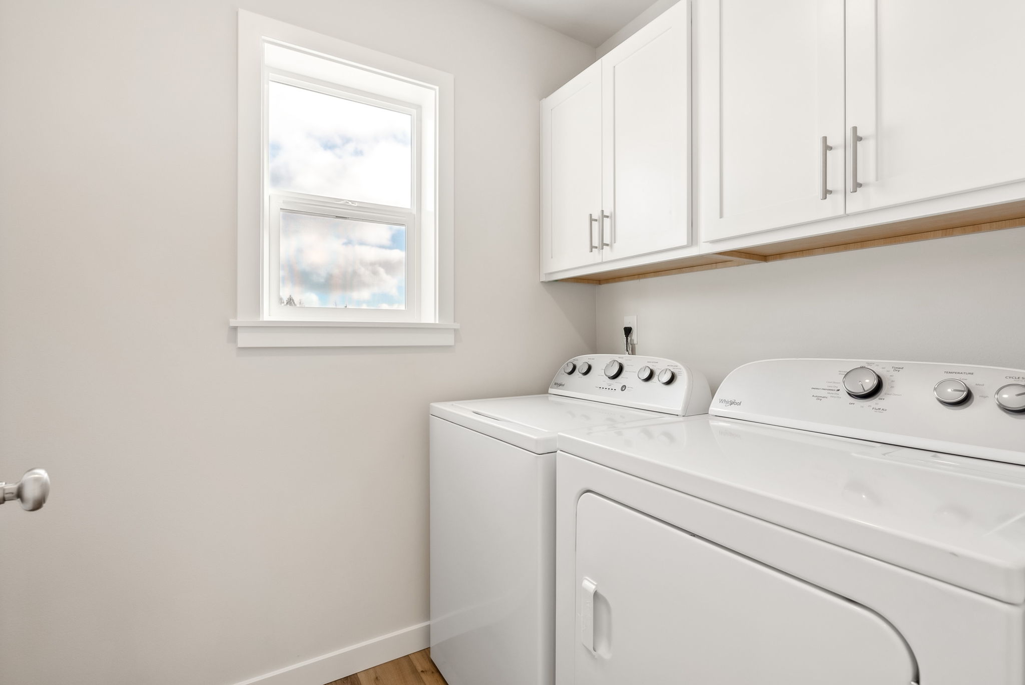 A white kitchen with a white stove and white cabinets.