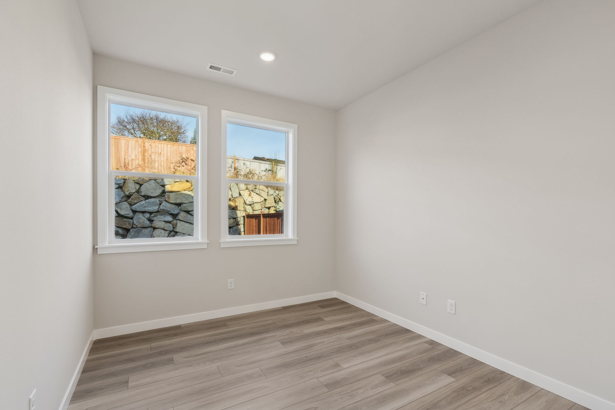 A room with a wood floor and windows.