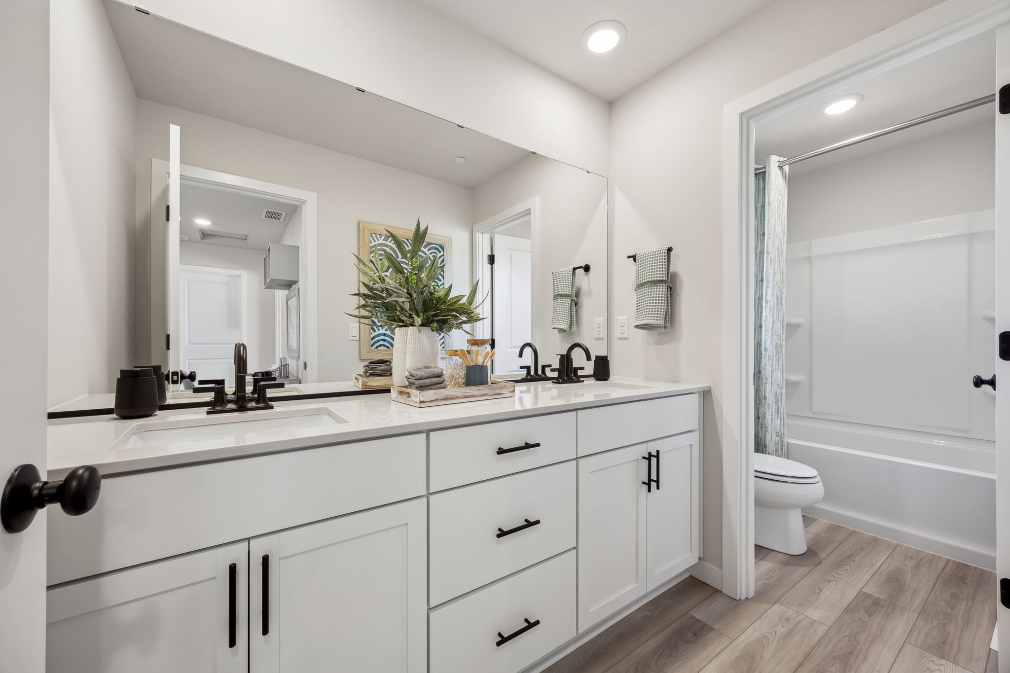 A bathroom with white cabinets.