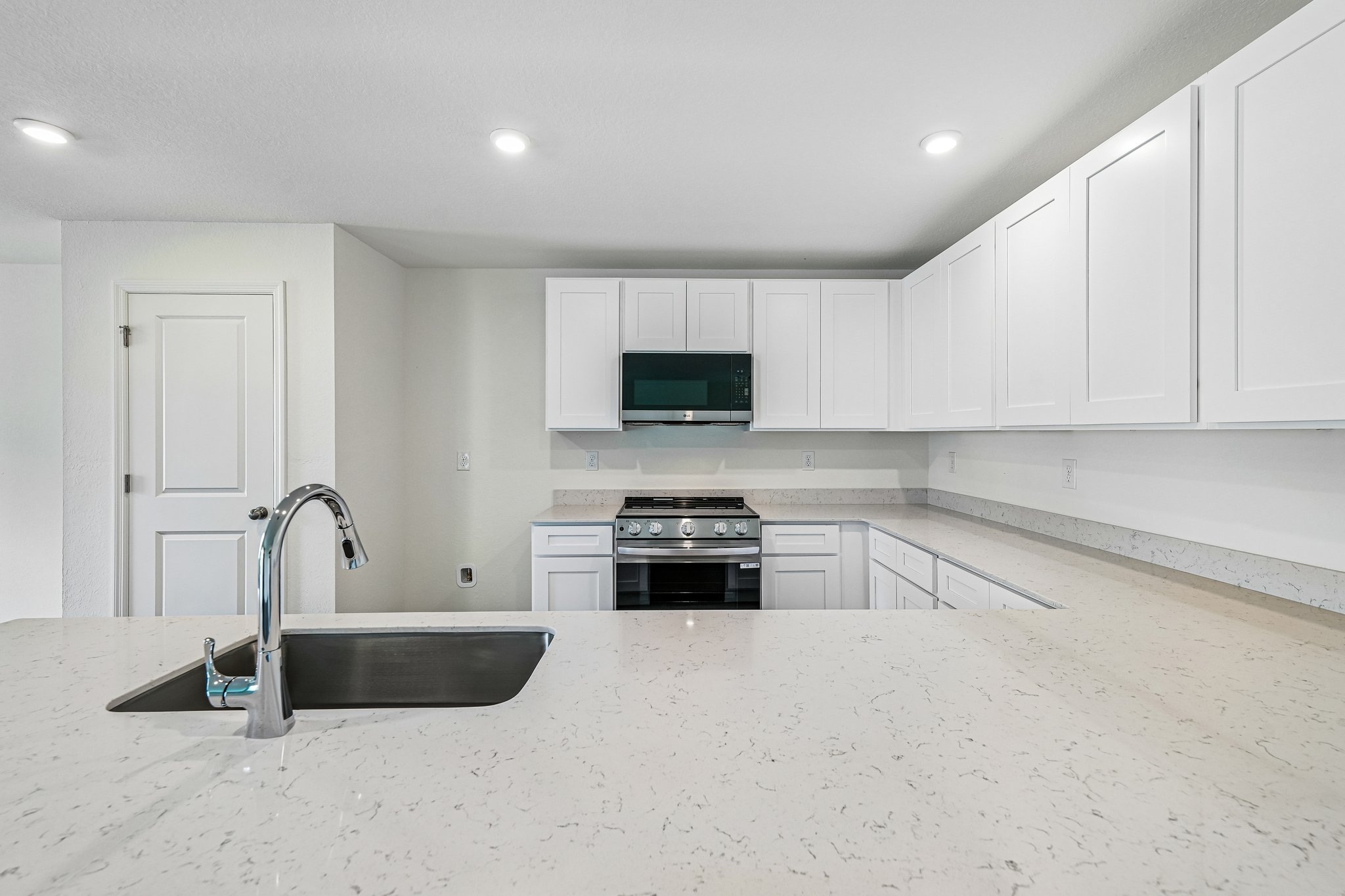 A kitchen with white cabinets.
