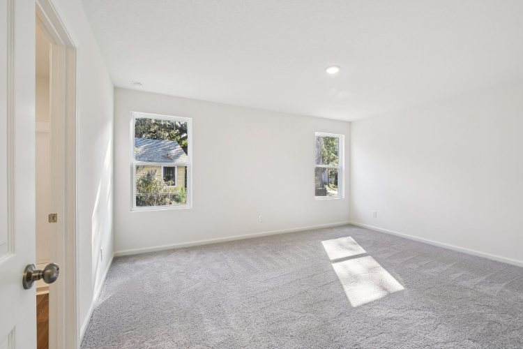 A room with a rug and pictures on the wall.