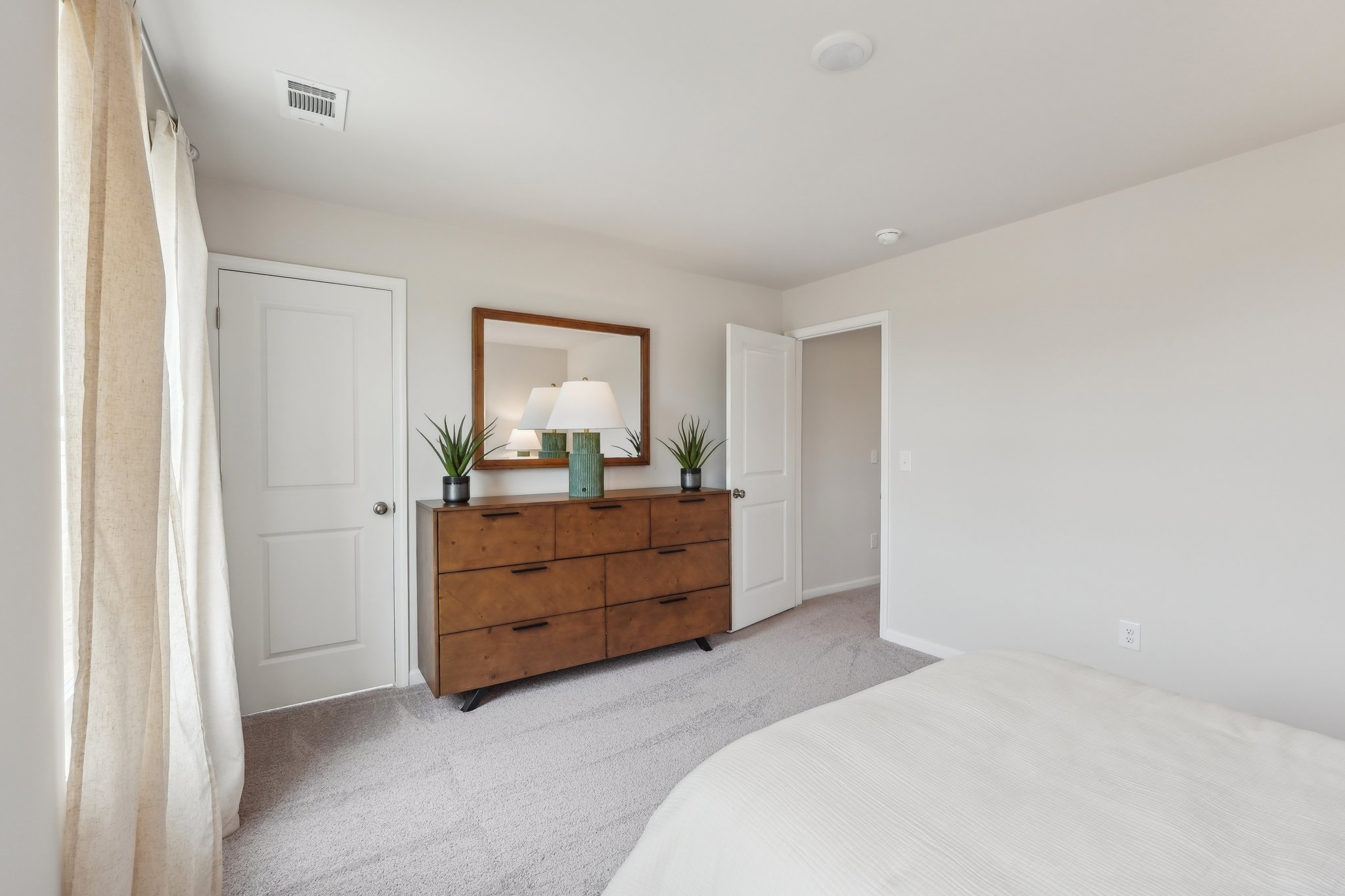 A bedroom with a bed and a dresser.