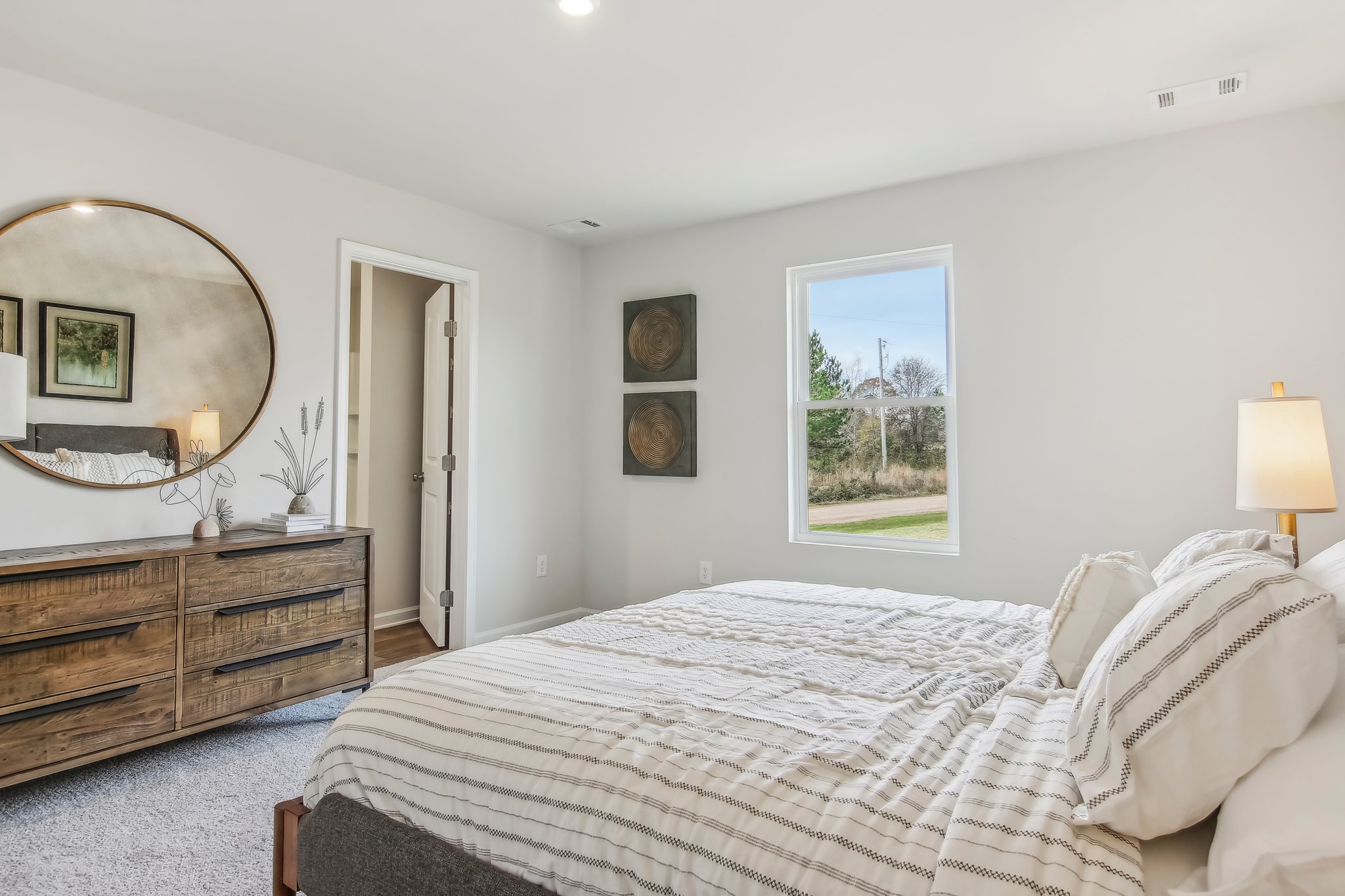 A bedroom with a large mirror.
