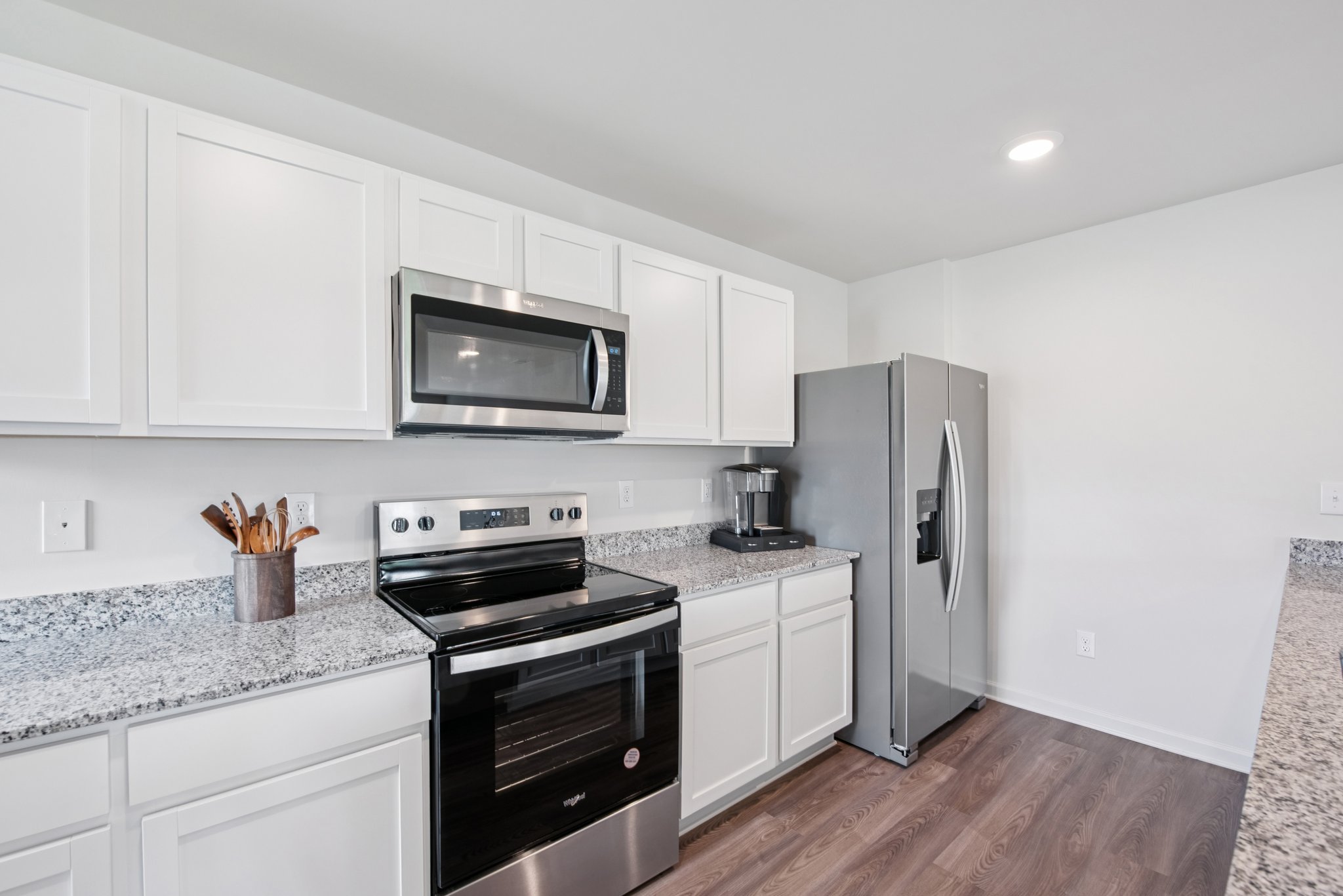 A kitchen with white cabinets.