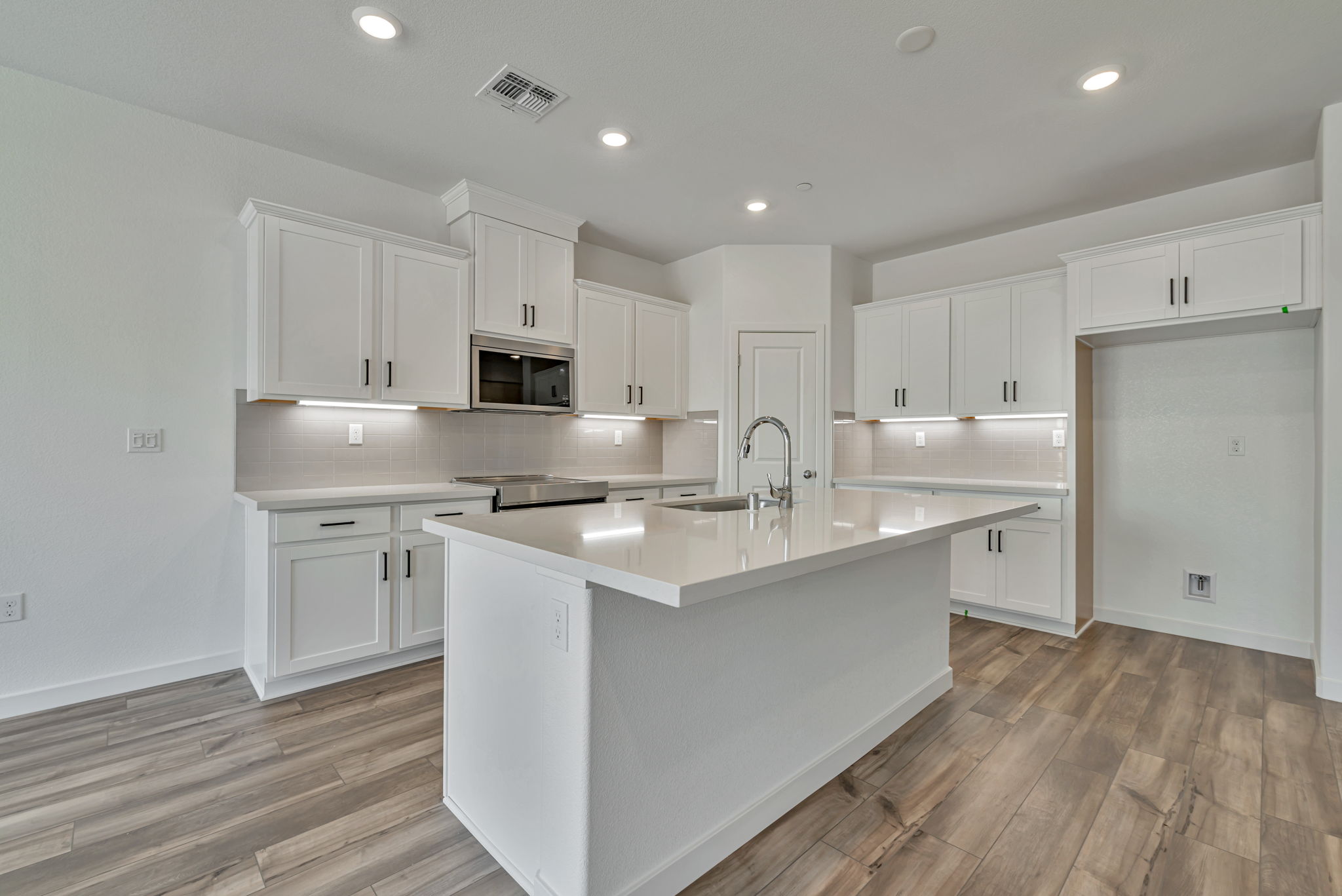 A kitchen with white cabinets.