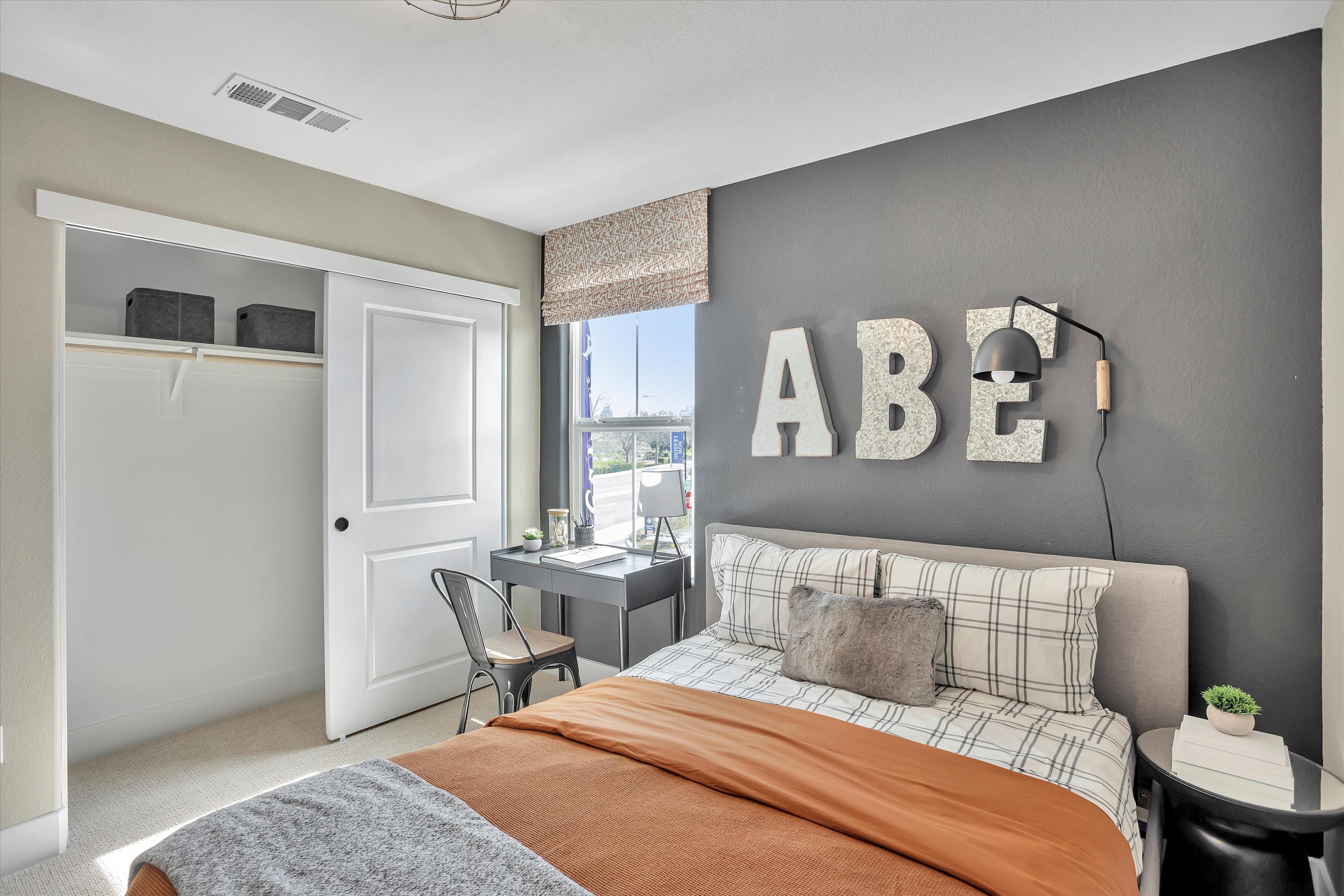 A bedroom with a bed and a chair.