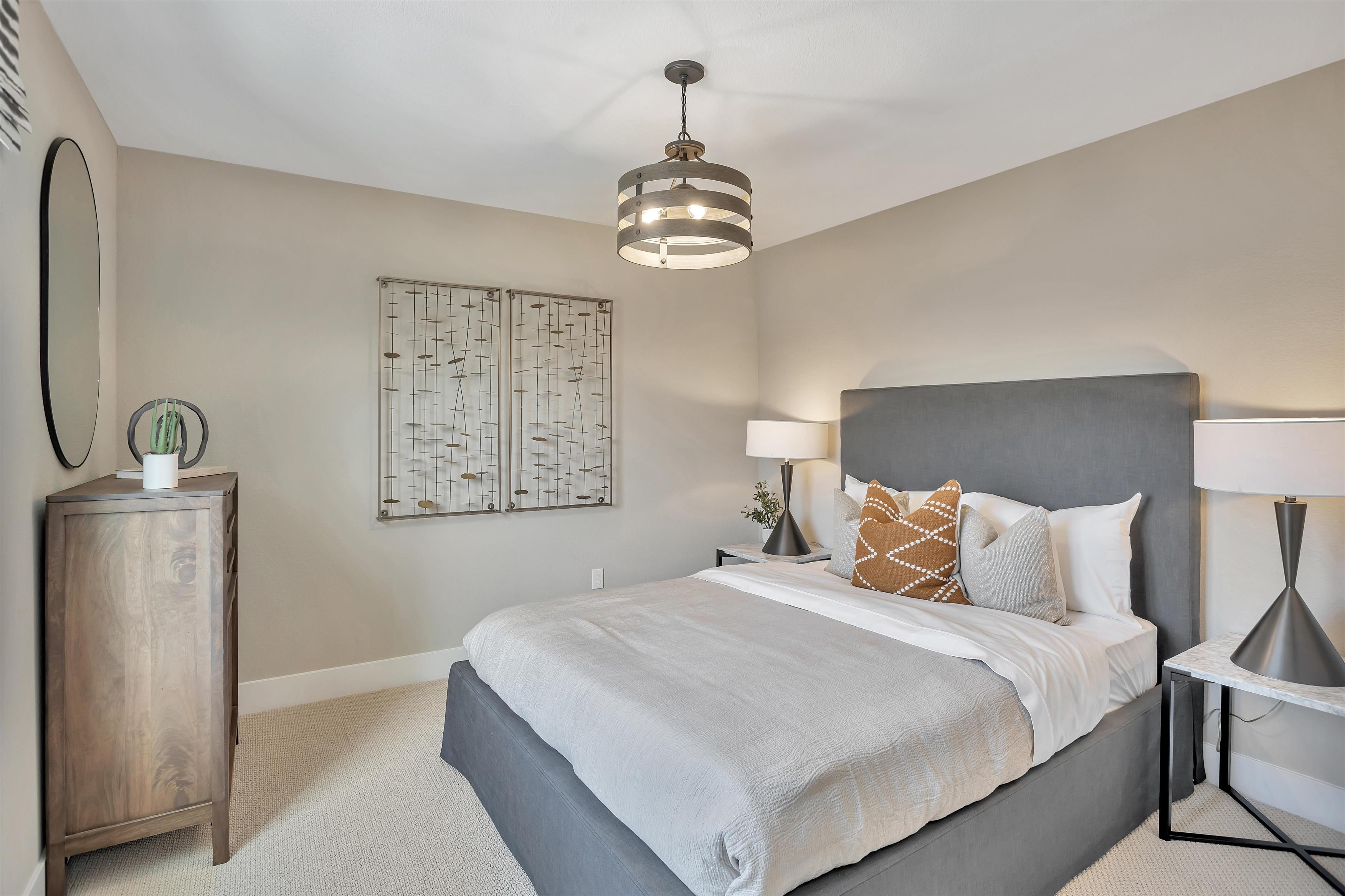 A bedroom with a bed and a lamp.